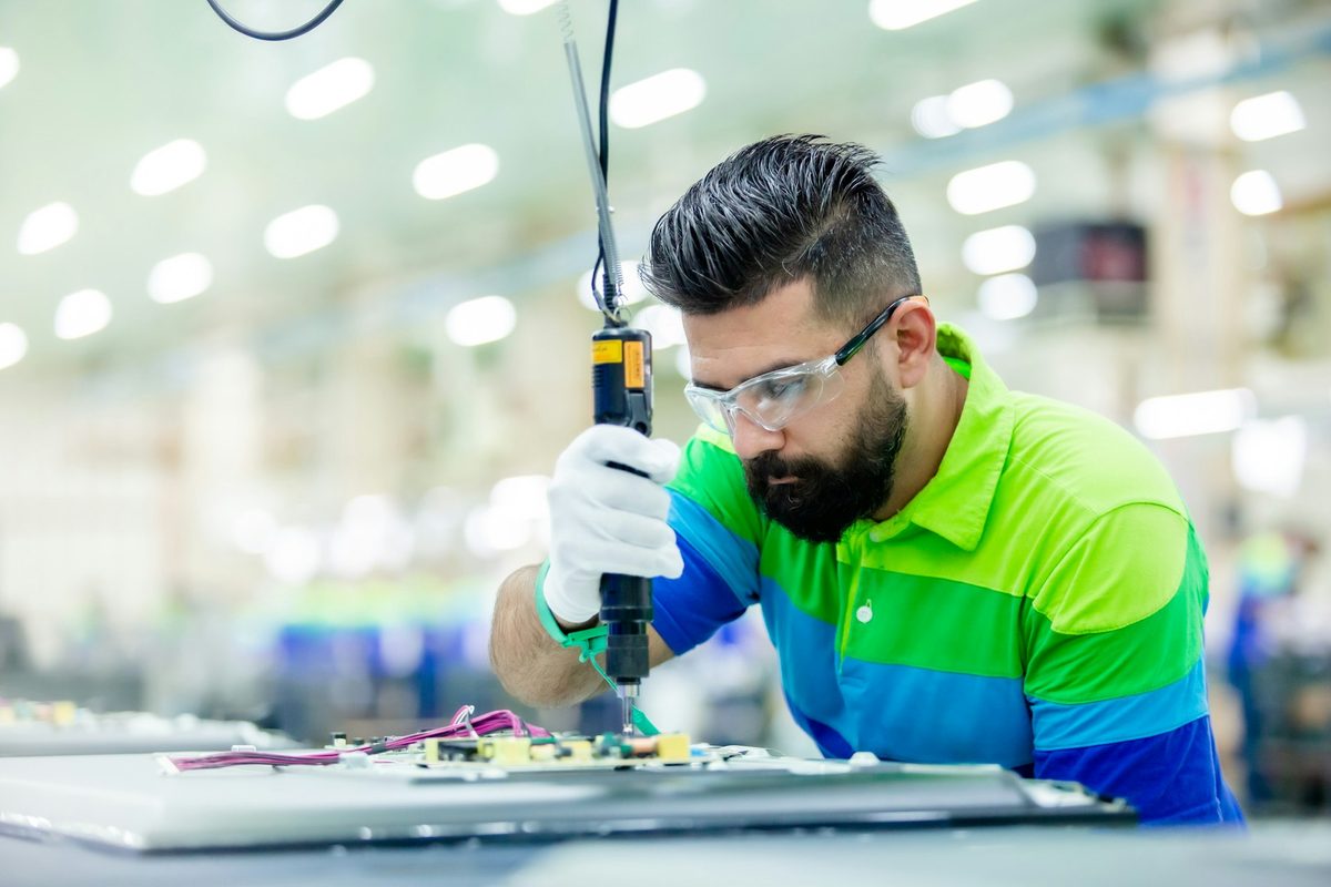 Technician assembling electronics in a workshop